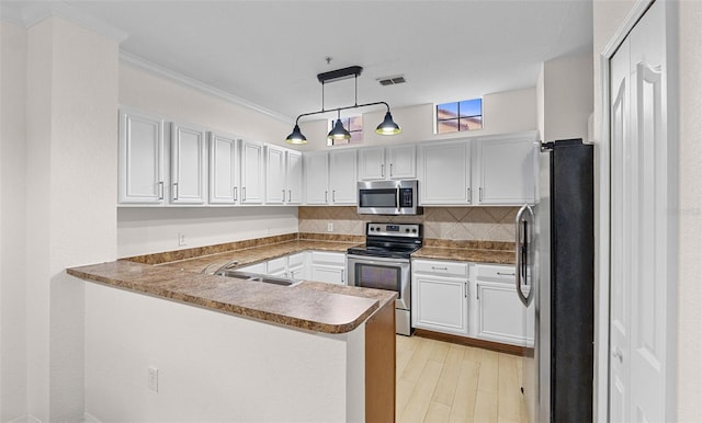 kitchen with visible vents, a peninsula, a sink, appliances with stainless steel finishes, and backsplash