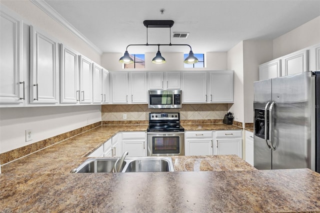 kitchen featuring visible vents, a sink, stainless steel appliances, white cabinets, and backsplash