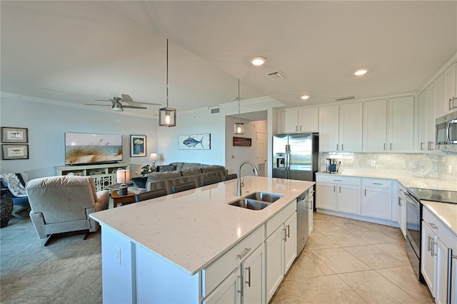 kitchen with a sink, tasteful backsplash, open floor plan, stainless steel appliances, and crown molding