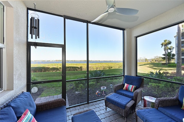 sunroom / solarium featuring a wealth of natural light, a rural view, and a ceiling fan