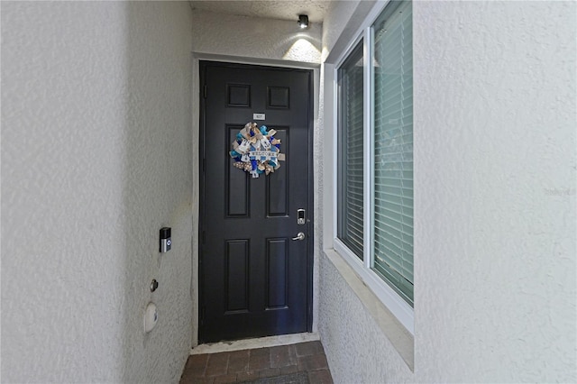 property entrance with stucco siding