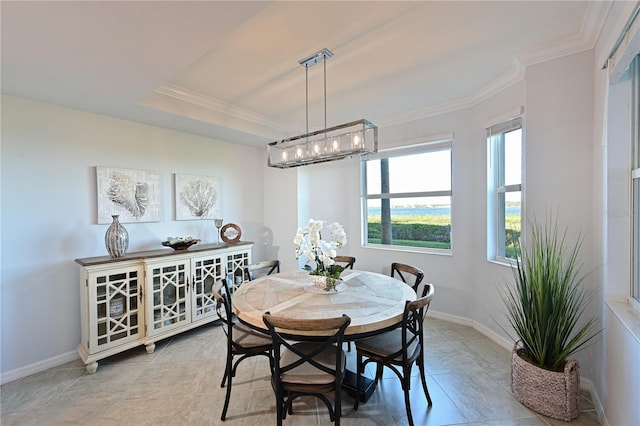 dining area featuring a tray ceiling, baseboards, and ornamental molding