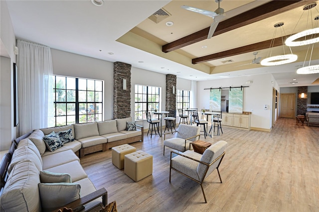 living area featuring beamed ceiling, visible vents, light wood-style flooring, baseboards, and ceiling fan