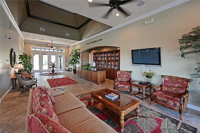 tiled living area featuring baseboards, arched walkways, a high ceiling, and ornamental molding