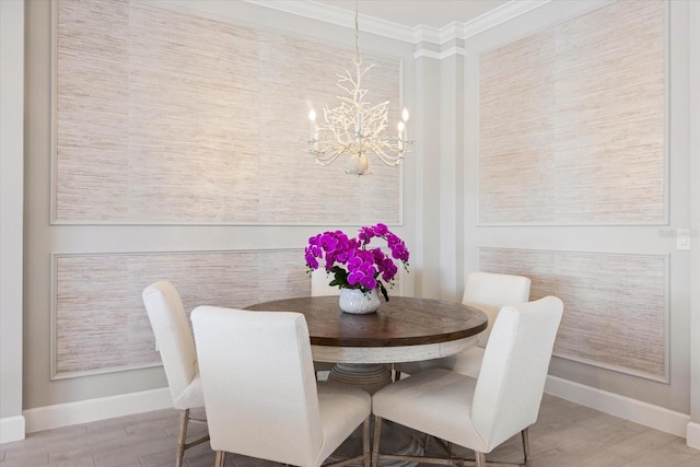 dining space with a notable chandelier, crown molding, baseboards, and wood finished floors