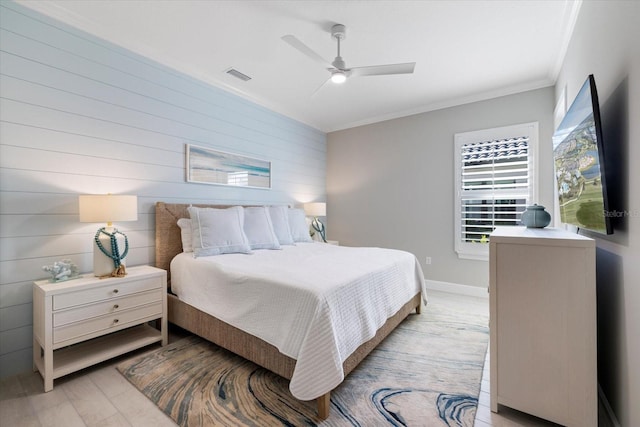 bedroom with visible vents, crown molding, baseboards, light wood-style flooring, and a ceiling fan