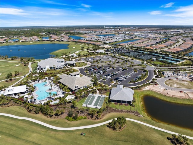 drone / aerial view with golf course view and a water view