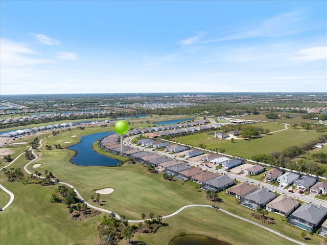 drone / aerial view featuring golf course view, a water view, and a residential view