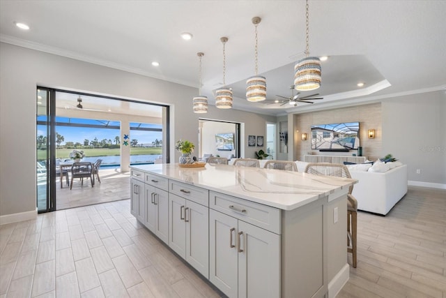 kitchen featuring ceiling fan, a kitchen breakfast bar, open floor plan, and a kitchen island