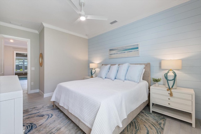 bedroom with baseboards, visible vents, ceiling fan, ornamental molding, and light wood-type flooring