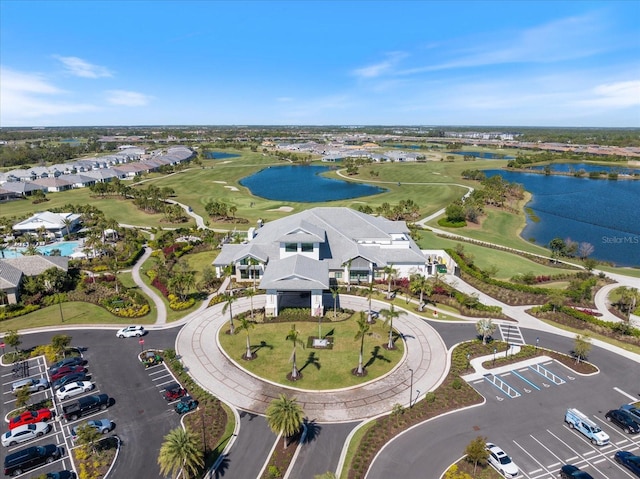 drone / aerial view with view of golf course and a water view