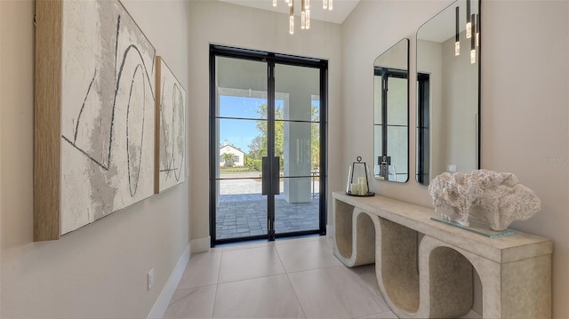 doorway with light tile patterned floors, french doors, and baseboards