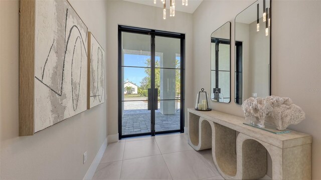 doorway with light tile patterned floors, french doors, and baseboards