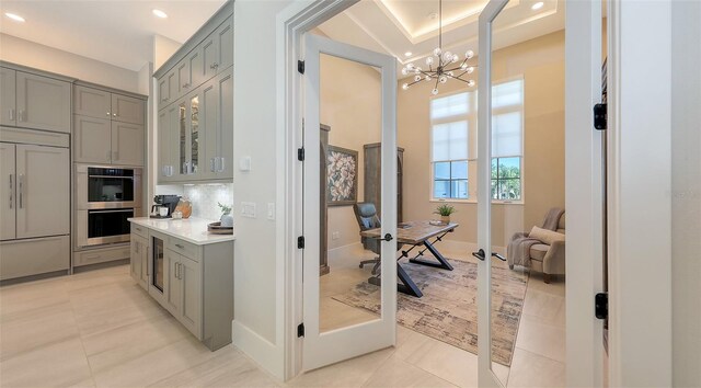 kitchen with light tile patterned flooring, gray cabinets, backsplash, and paneled refrigerator