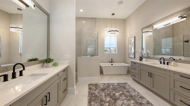 bathroom featuring a tile shower, an inviting chandelier, and a sink