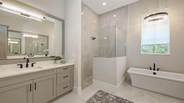 bathroom featuring vanity, a soaking tub, a walk in shower, and baseboards