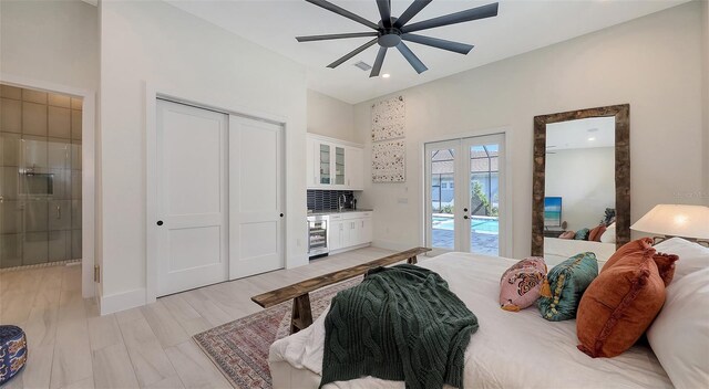 bedroom with access to exterior, baseboards, wine cooler, light wood-style flooring, and french doors