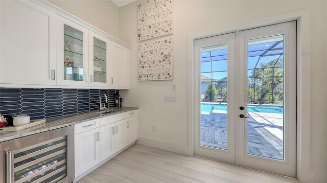 entryway featuring beverage cooler, baseboards, and a sink