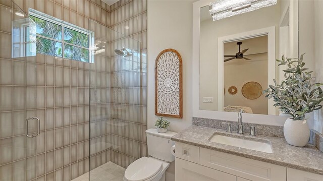 full bathroom featuring a shower stall, toilet, vanity, and ceiling fan