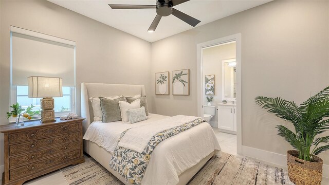 bedroom featuring light tile patterned flooring, connected bathroom, and baseboards