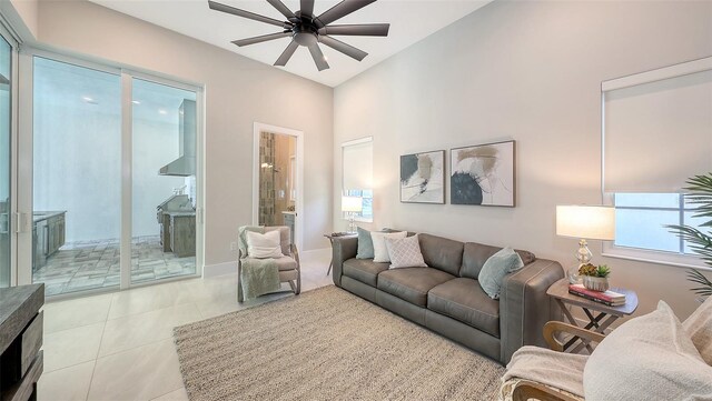 living room featuring baseboards, a ceiling fan, and tile patterned flooring