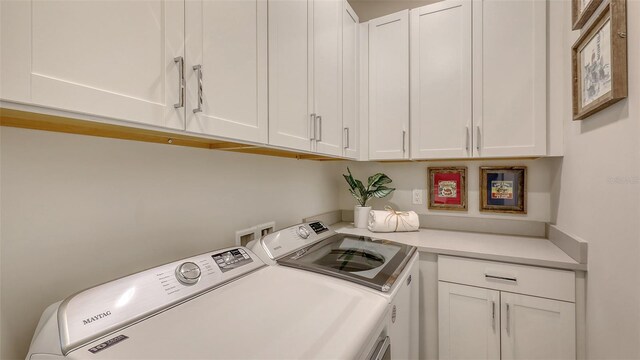 laundry room with washing machine and clothes dryer and cabinet space