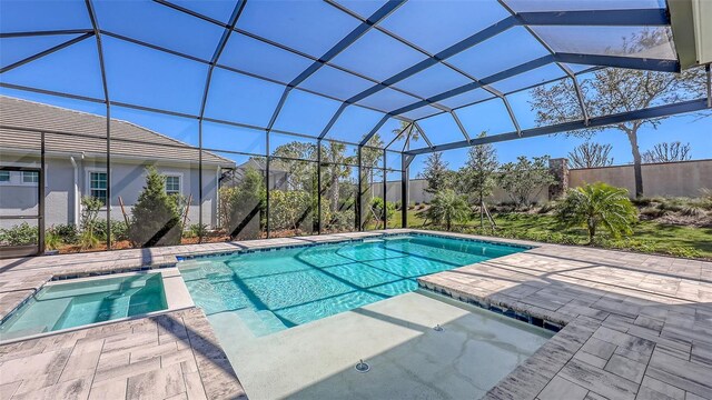 view of swimming pool featuring a patio, a lanai, and a pool with connected hot tub