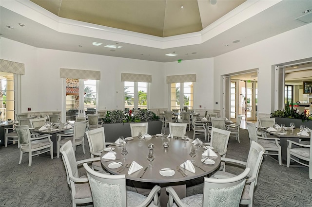 dining area with a high ceiling and carpet floors