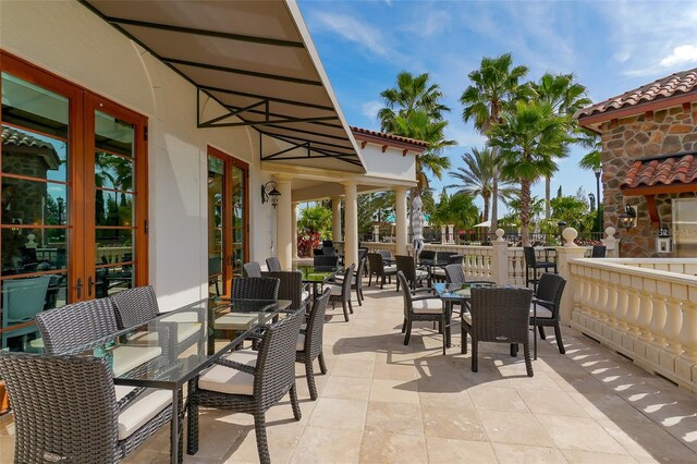 view of patio featuring french doors, outdoor dining area, and fence