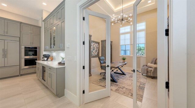 8348 Catamaran Cir, Lakewood Ranch, FL 34202 - interior space featuring light tile patterned floors, paneled fridge, an inviting chandelier, and gray cabinets