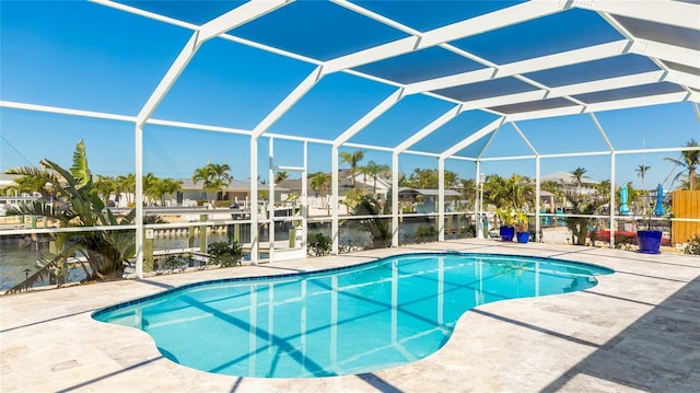 pool featuring glass enclosure and a patio area