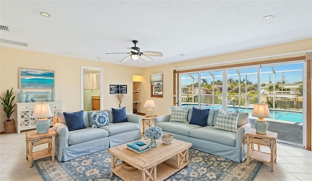 living area with light tile patterned floors, visible vents, and ceiling fan