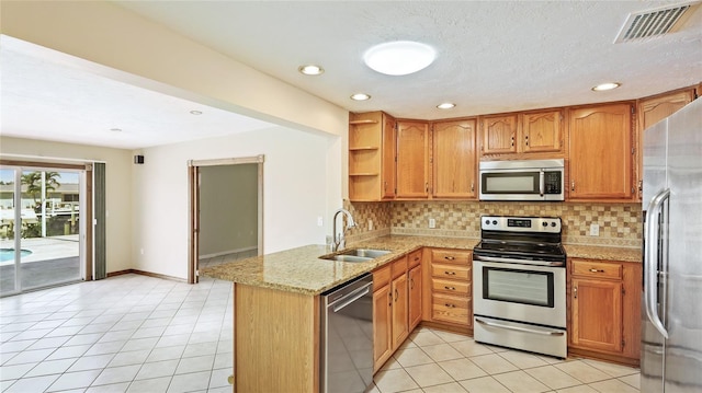 kitchen featuring visible vents, a sink, stainless steel appliances, a peninsula, and light tile patterned floors