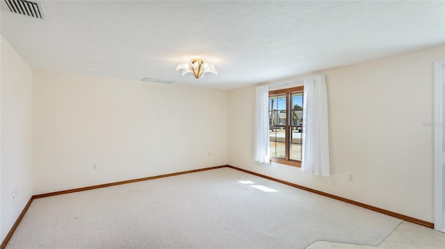 spare room featuring visible vents, baseboards, and light colored carpet