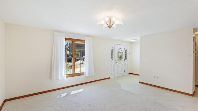 foyer entrance featuring tile patterned floors, baseboards, an inviting chandelier, and carpet flooring