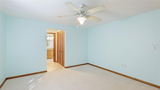 empty room with baseboards, light carpet, and ceiling fan