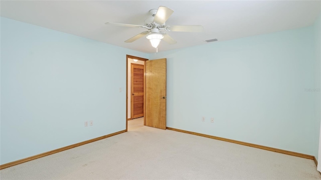 unfurnished room with light carpet, visible vents, a ceiling fan, and baseboards