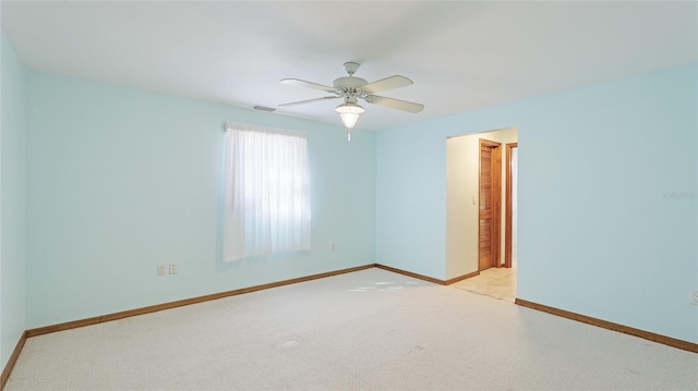 unfurnished room featuring light colored carpet, baseboards, visible vents, and ceiling fan