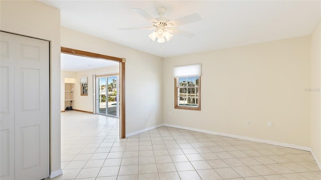 spare room featuring light tile patterned flooring, baseboards, and a ceiling fan