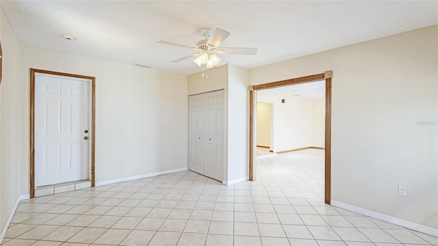 empty room with light tile patterned floors, baseboards, and ceiling fan