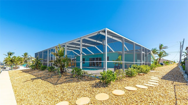 back of house featuring a lanai and an outdoor pool