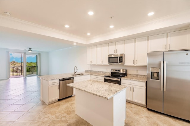 kitchen featuring crown molding, a peninsula, white cabinets, stainless steel appliances, and a sink