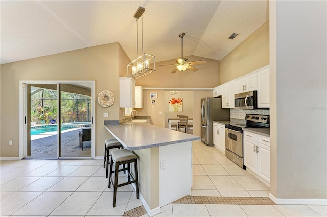 1127 133rd St E, Bradenton, FL 34212 - kitchen featuring a kitchen bar, light tile patterned floors, ceiling fan with notable chandelier, visible vents, and appliances with stainless steel finishes