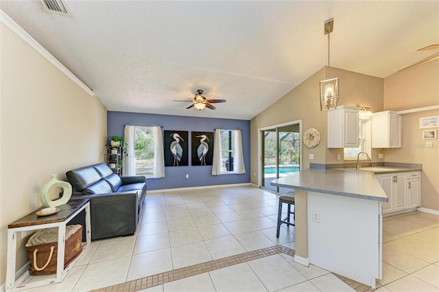 1127 133rd St E, Bradenton, FL 34212 - kitchen with light tile patterned floors, visible vents, a kitchen bar, and ceiling fan