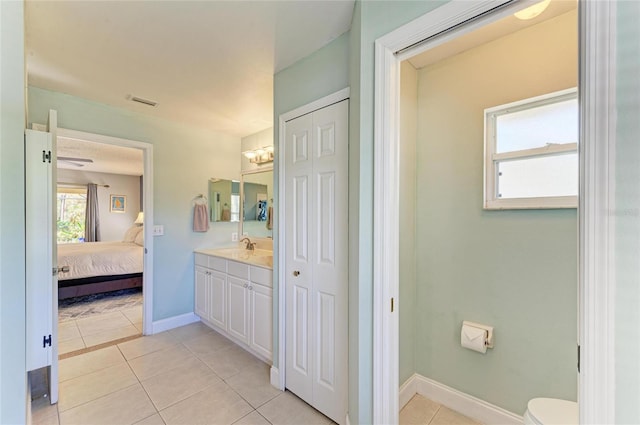 1127 133rd St E, Bradenton, FL 34212 - ensuite bathroom with baseboards, connected bathroom, toilet, vanity, and tile patterned flooring
