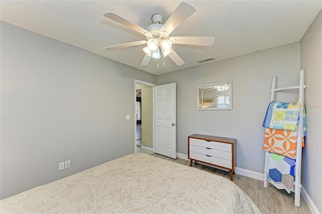 1127 133rd St E, Bradenton, FL 34212 - bedroom with a textured ceiling, visible vents, baseboards, wood finished floors, and a ceiling fan