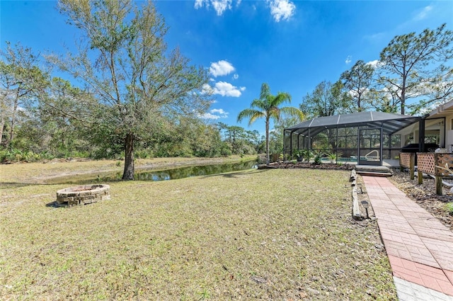 1127 133rd St E, Bradenton, FL 34212 - view of yard featuring glass enclosure, a water view, and an outdoor fire pit