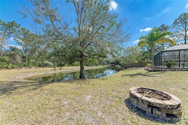 1127 133rd St E, Bradenton, FL 34212 - view of yard with glass enclosure, an outdoor fire pit, a water view, and fence