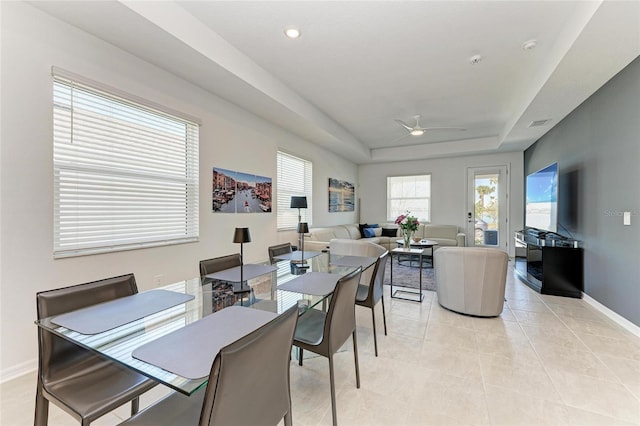 dining space featuring a raised ceiling, a ceiling fan, recessed lighting, light tile patterned flooring, and baseboards