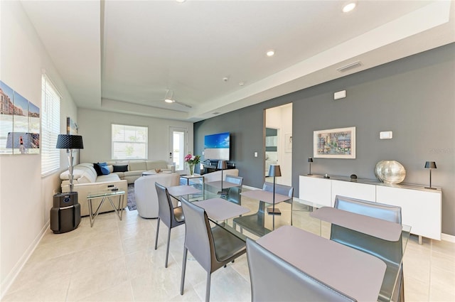 dining space with visible vents, a tray ceiling, recessed lighting, light tile patterned flooring, and baseboards